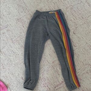 Gray aviator nation sweatpants with red orange and blue strips down the side
